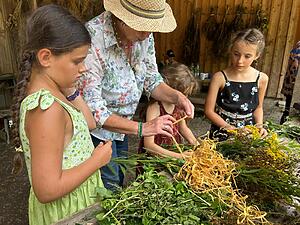 Kinder binden Kräuterbüschele für die Kräuterweihe